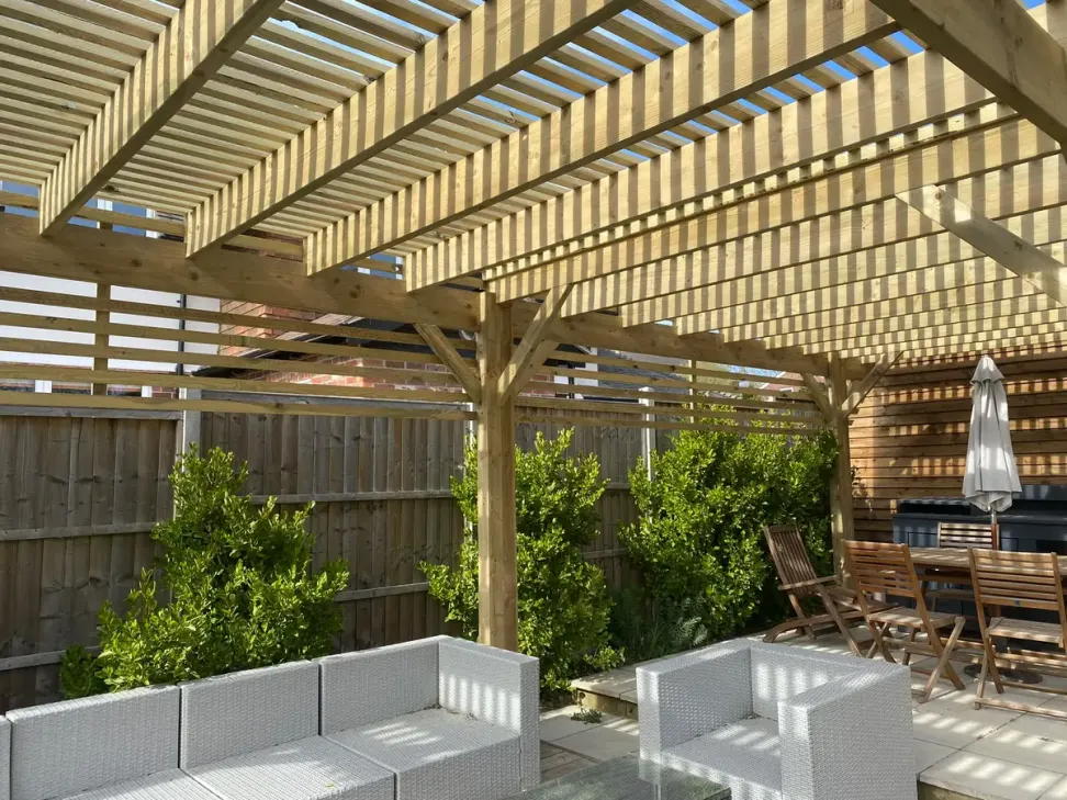 Slatted timber pergola over garden seating and dining area